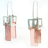 Pair of earrings with pink and red rectangular designs on a white background
