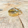 Two gold wedding rings with diamonds on a wooden surface